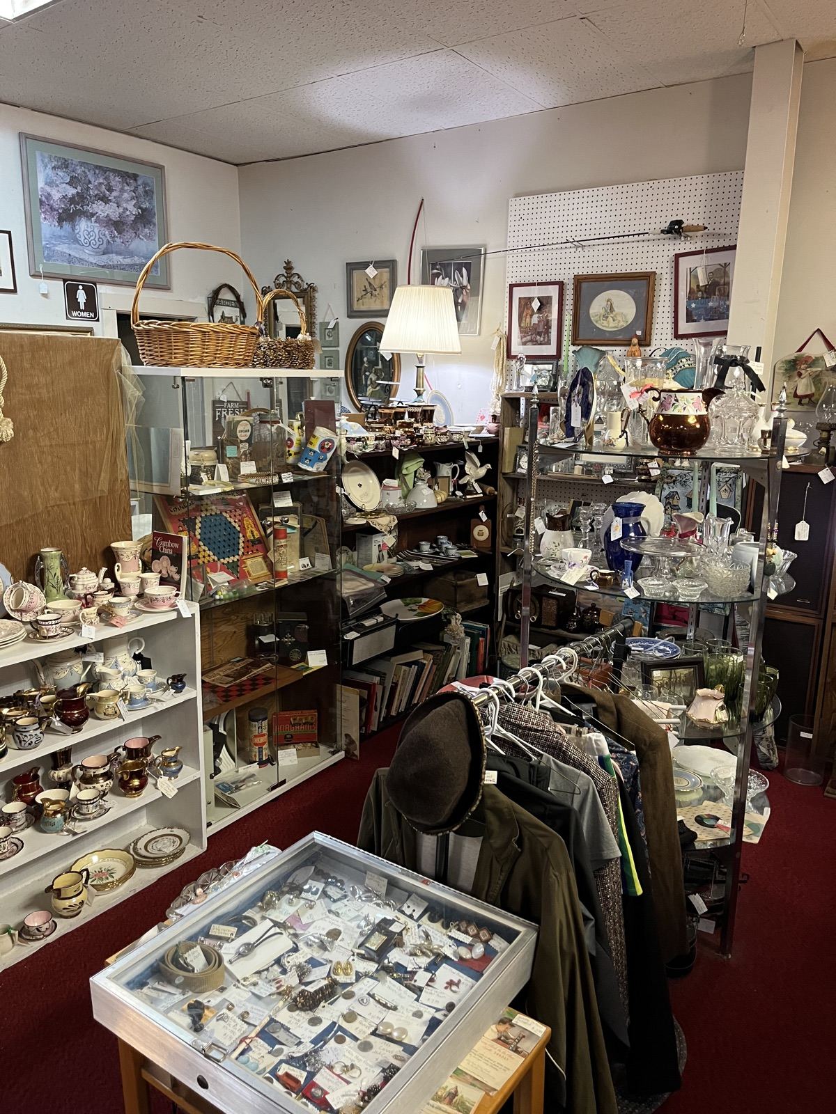 Framed art above cases of china and collectibles